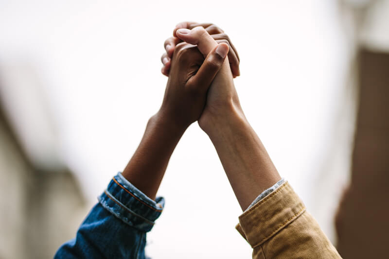 Two hands raised and clasped together